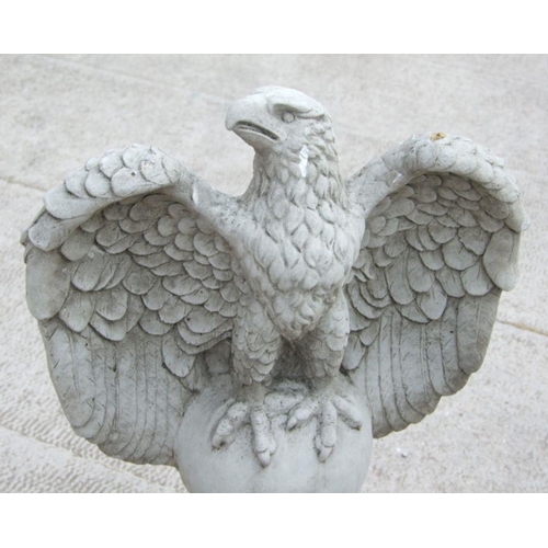 14 - A large pair of stoneware garden eagles perched on a sphere with their wings outswept, 97cms high (2... 