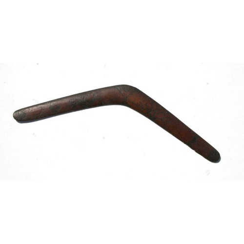 202 - An early 20th century Aboriginal boomerang with carved decoration, 61cms wide.