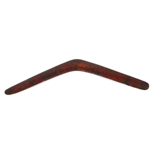 202 - An early 20th century Aboriginal boomerang with carved decoration, 61cms wide.