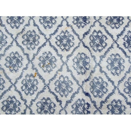 279 - A Persian hand knotted blue & cream woollen rug with repeated floral medallions, 212 by 121cms; ... 