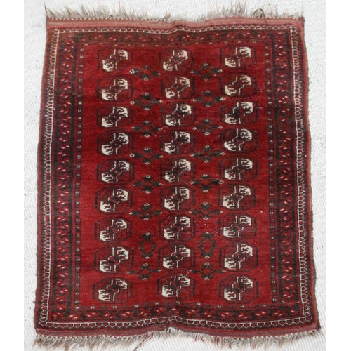 281 - A Persian woollen Turkoman rug with repeating rows of guls within borders, on a red ground.