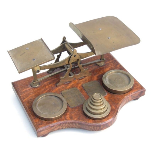 477 - A large set of oak and brass postal scales with graduated brass weights, 37cms wide.