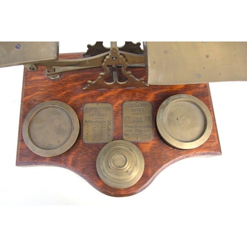 477 - A large set of oak and brass postal scales with graduated brass weights, 37cms wide.