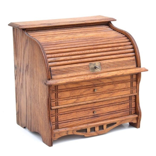 479 - A miniature oak table top roll-top desk stamp box, the tambour top enclosing a fitted interior above... 