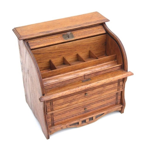 479 - A miniature oak table top roll-top desk stamp box, the tambour top enclosing a fitted interior above... 