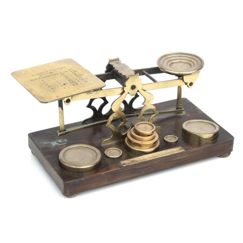 483 - A Victorian S Morden & Co set of brass postal scales and weights on a walnut base, 27cms wide.