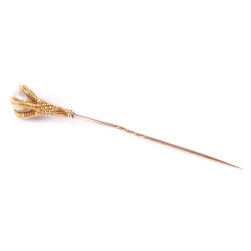 755 - An antique French yellow metal (tests as 18ct gold) stick pin in the form of an eagles claw clasping... 