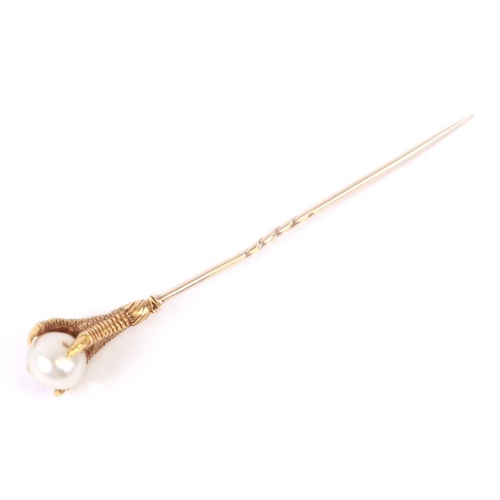 755 - An antique French yellow metal (tests as 18ct gold) stick pin in the form of an eagles claw clasping... 