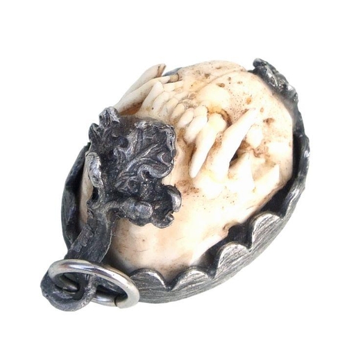 764 - A Charivari German huntsman pendant with a full set of pole cat teeth, 3.5cms long.