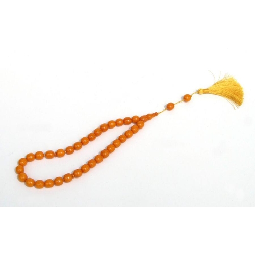 775 - A string of amber like worry beads.