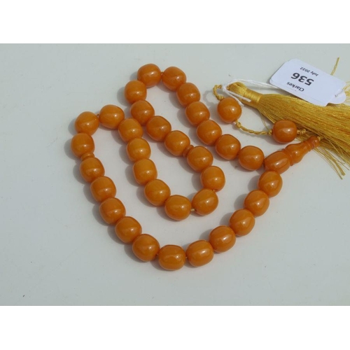 775 - A string of amber like worry beads.