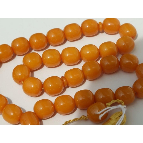 775 - A string of amber like worry beads.