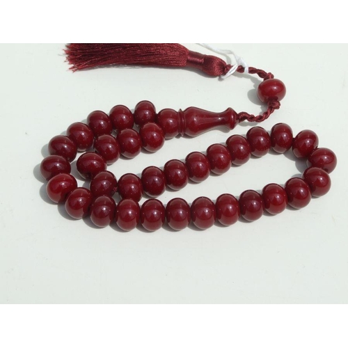 776 - A cherry amber Bakelite style string of worry beads.