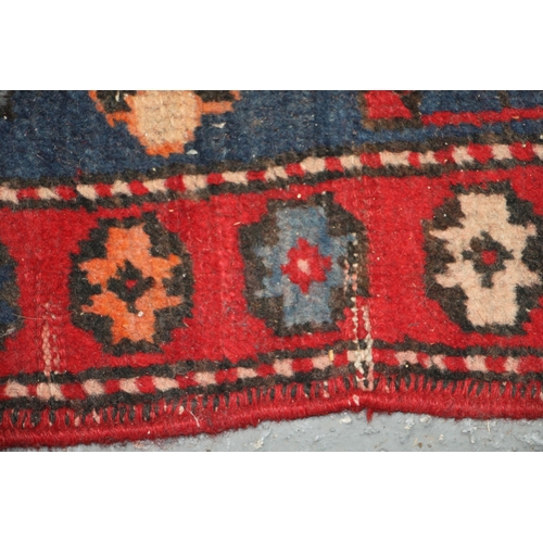 287 - A Persian Azari hand knotted woollen runner with five stylised guls within floral borders, on a blue... 