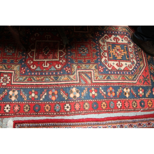 287 - A Persian Azari hand knotted woollen runner with five stylised guls within floral borders, on a blue... 