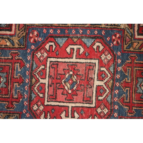 287 - A Persian Azari hand knotted woollen runner with five stylised guls within floral borders, on a blue... 