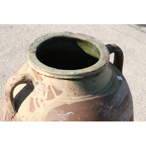 35 - A large Mediterranean terracotta two-handled olive jar with green glazed banded rim, 55cms high.