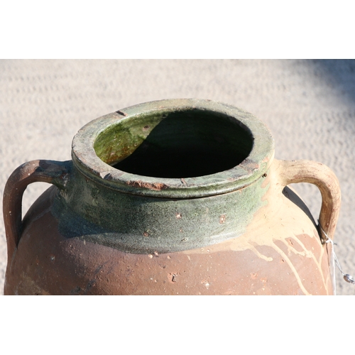 35 - A large Mediterranean terracotta two-handled olive jar with green glazed banded rim, 55cms high.