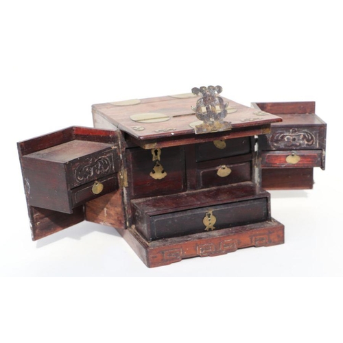 1004 - A Chinese hardwood dressing table chest with fitted interior and brass mounts, 30cms wide. (a/f)