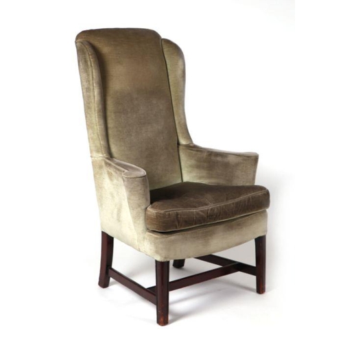 1012 - A Georgian style upholstered wingback armchair, on a mahogany frame.