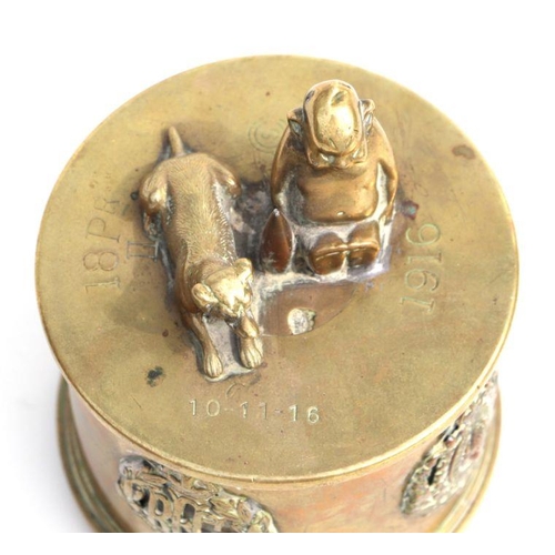 147 - A WWI trench art tobacco jar and over with applied cap badges including RF, American North West Moun... 