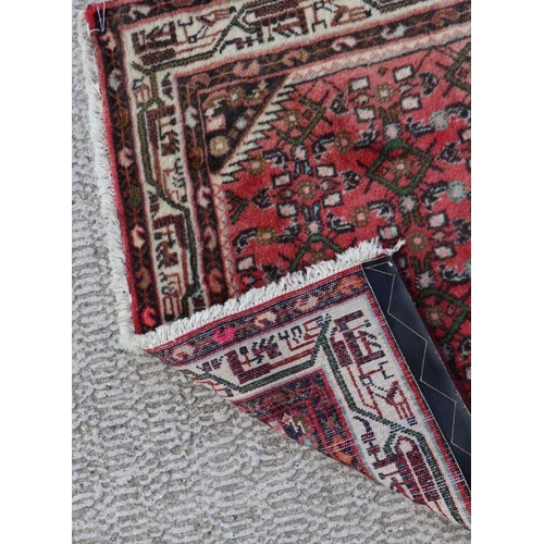 195 - A Persian runner with geometric design on a red ground within a multi border, 282 by 81cms.