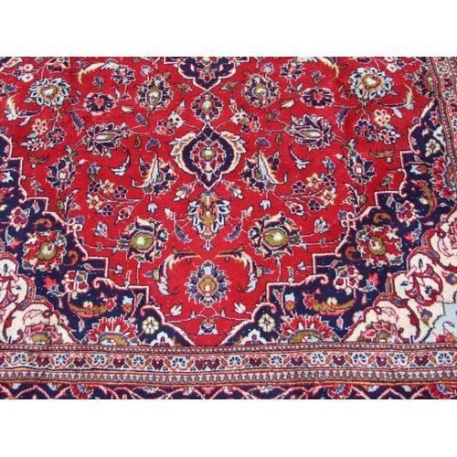 202 - A Persian Kashan woollen hand knotted rug, the central medallion with floral sprays and borders, 290... 