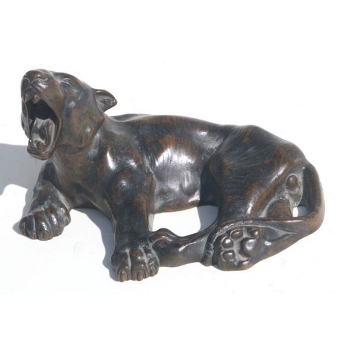 475 - A bronze study of a yawning recumbent tiger, 16cms long.