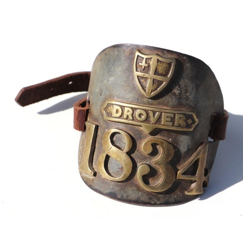 491 - An early 19th century brass drover's armband with leather strap, numbered 1834, 11cms high.