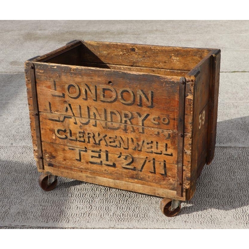 998 - A pine laundry cart 'London Laundry Co, Clerkenwell', on four cast wheels, 87cms wide.