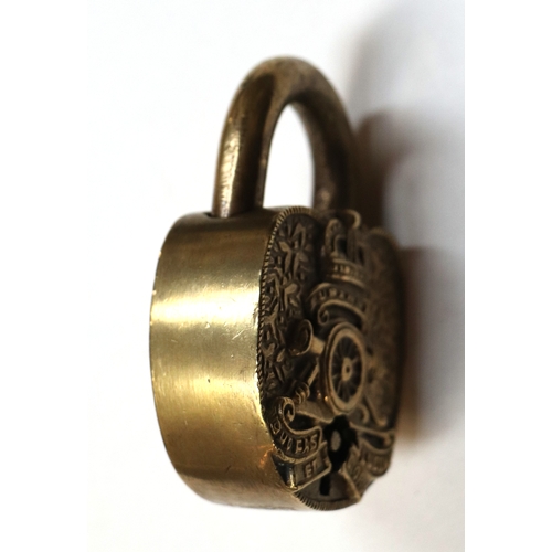 124 - A heavy brass Artillery Ubique padlock with key in full working order. 6.5cms (2.5ins) wide by 9cms ... 