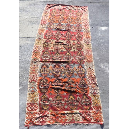 153E - A large kilim rug or wall hanging with repeat design on a beige ground, 365 by 139cms.