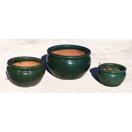 2 - A set of three green glazed terracotta pots, the largest 45cms diameter (3).