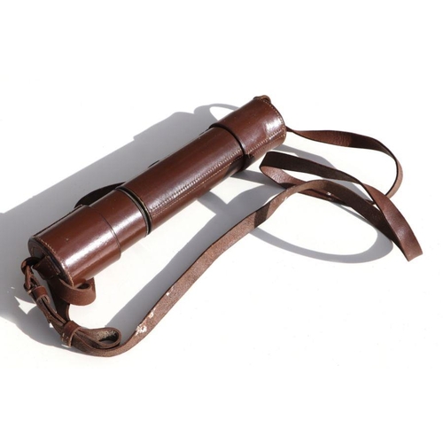 64 - A vintage two draw field telescope complete with its original stitched leather covering and linked e... 