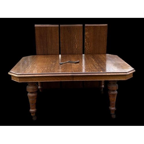 861 - A late Victorian oak extending dining table, the rectangular top with canted corners, with three ext... 