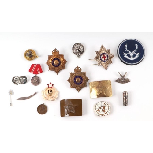 96 - A small collection of militaria to include belt buckles, cap badges, medal ribbons, inert bullets an... 