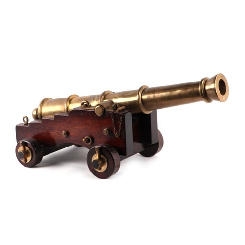 1510 - A brass or bronze cannon mounted on a wooden carriage with brass/bronze fittings and a wooden wedge.... 