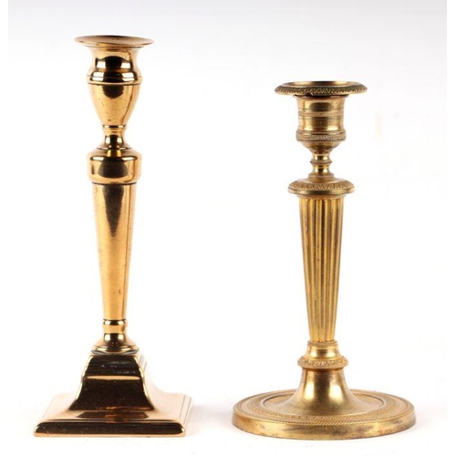 169 - A brass candlestick in the Adam taste, 21cms high; together with another similar, 19cms high (2).