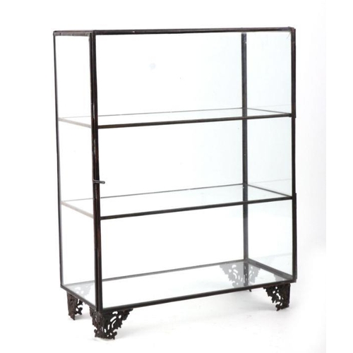 181 - A small tabletop brass and glass collector's display cabinet with two internal shelves, on pierced f... 