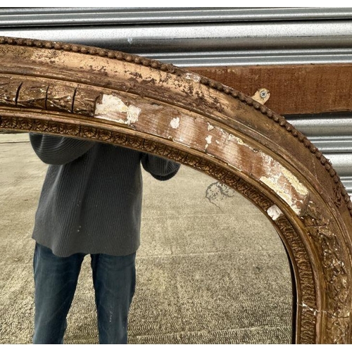 2190 - A large Victorian arch topped giltwood and gesso overmantle mirror with original ceramic bun feet an... 