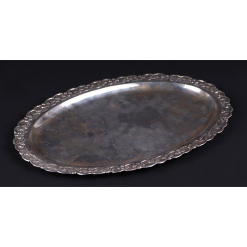 362 - A white metal oval tray with foliate embossed decoration, marked silver, 29cms wide, 255g.