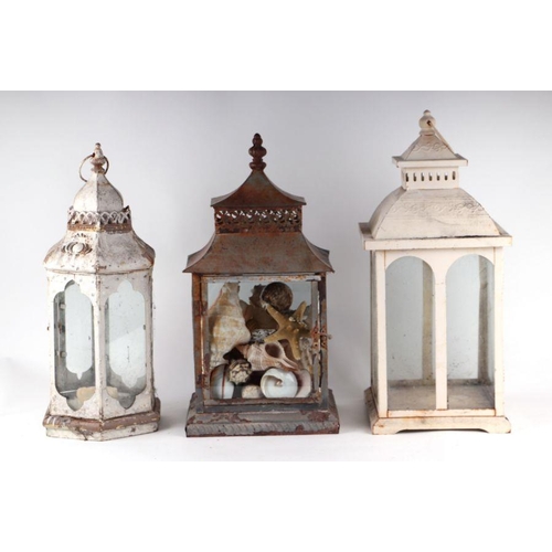 4 - Three painted metal storm lanterns, one containing a collection of seashells, largest 53cms high (3)... 