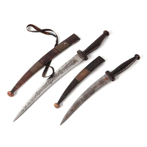 806 - A Middle Eastern type dagger with engraved steel blade, in a leather scabbard, 44cms long; together ... 