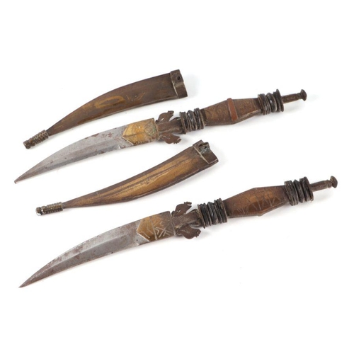 97 - A pair of Eastern daggers with brass handles and scabbards, each 27cms long (2).