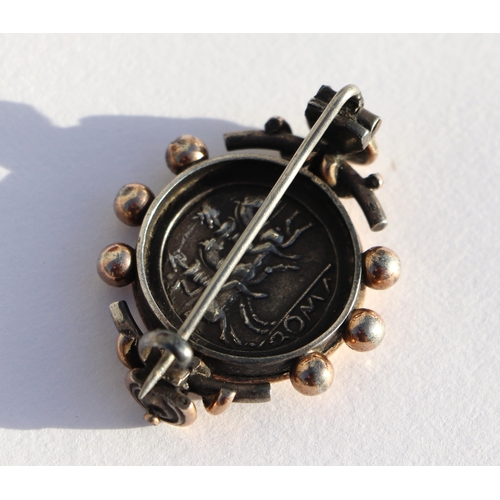 403 - A Victorian silver and gold brooch inset with a silver Roman / Greek coin.