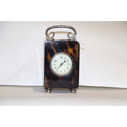 303 - A silver mounted tortoiseshell carriage time piece on bun feet with scroll handle, London 1920, 9cms... 