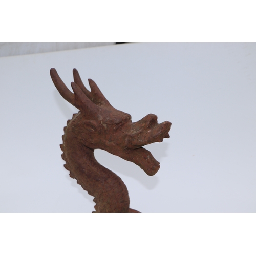 228 - A large well weathered Chinese style iron dragon head doorstop / finial, 35cms high.