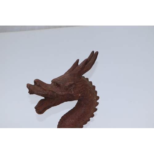 228 - A large well weathered Chinese style iron dragon head doorstop / finial, 35cms high.