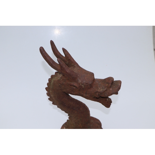 228 - A large well weathered Chinese style iron dragon head doorstop / finial, 35cms high.