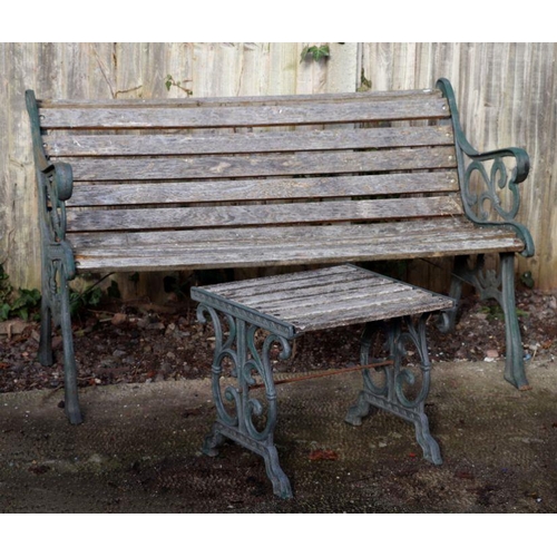 1 - A slatted wooden garden bench with cast iron ends, 148cms wide; together with a matching table, 46cm... 